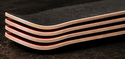 Four stacked skateboard decks with visible nose and tail kick